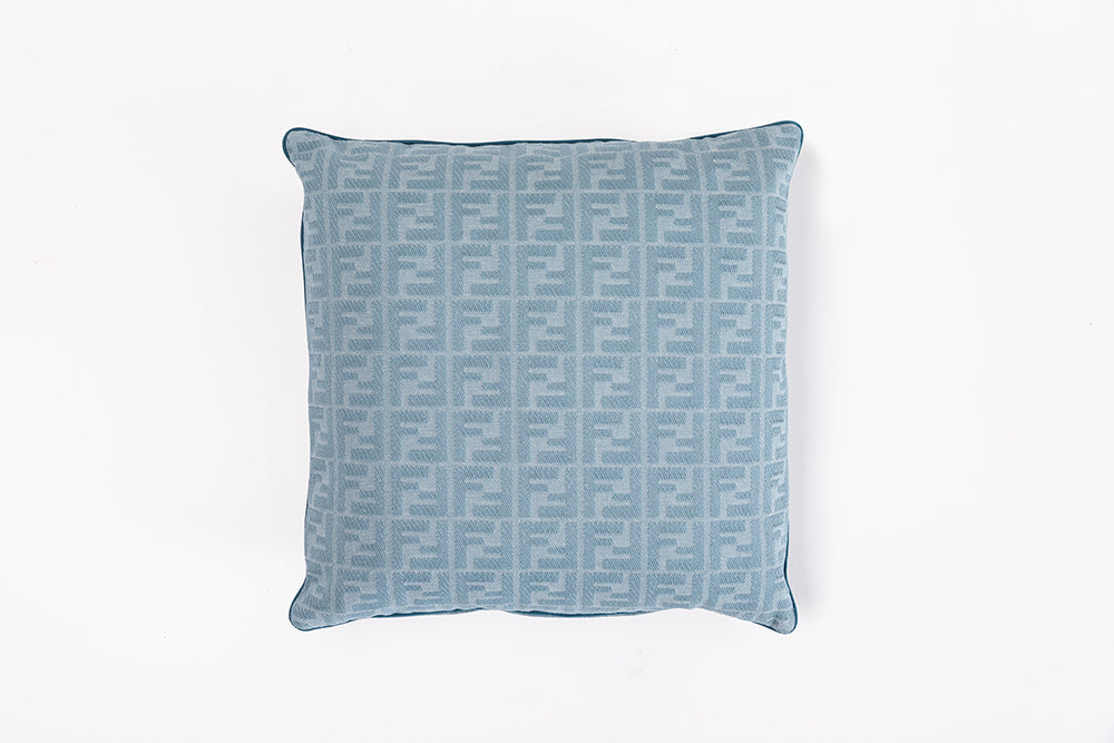 FF logo patterned cushion in light blue fabric, emphasizing luxury design statement furniture Fendi Casa